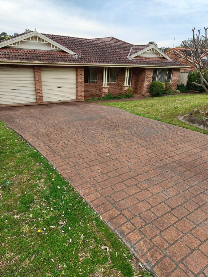 A Dirty Driveway Leading To A Brick House — Jervis Bay Pressure Washing & Property Maintenance in Sanctuary Point, NSW