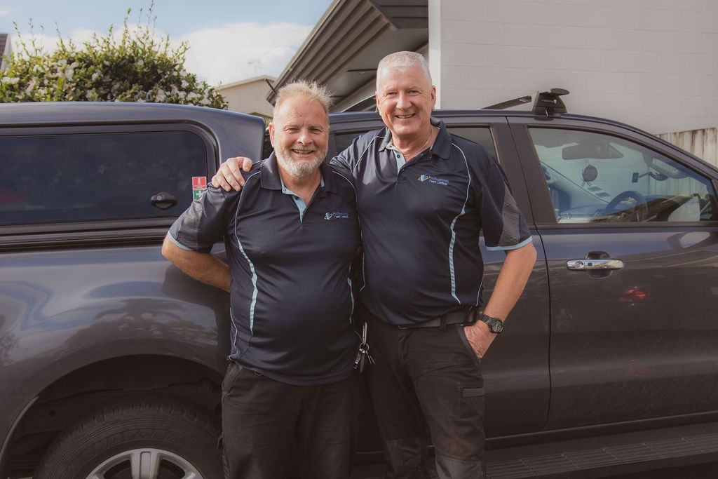 Stu & Duncan standing next to each other in front of a truck.