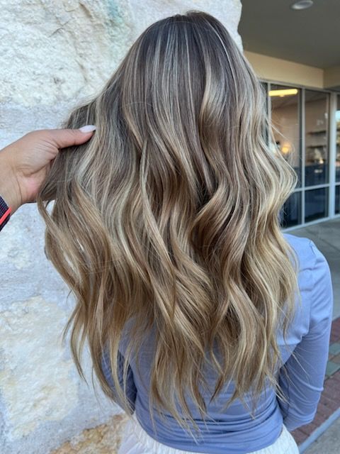 Person with wavy, lavender-toned bob hairstyle. A hand is holding the hair. Indoors.