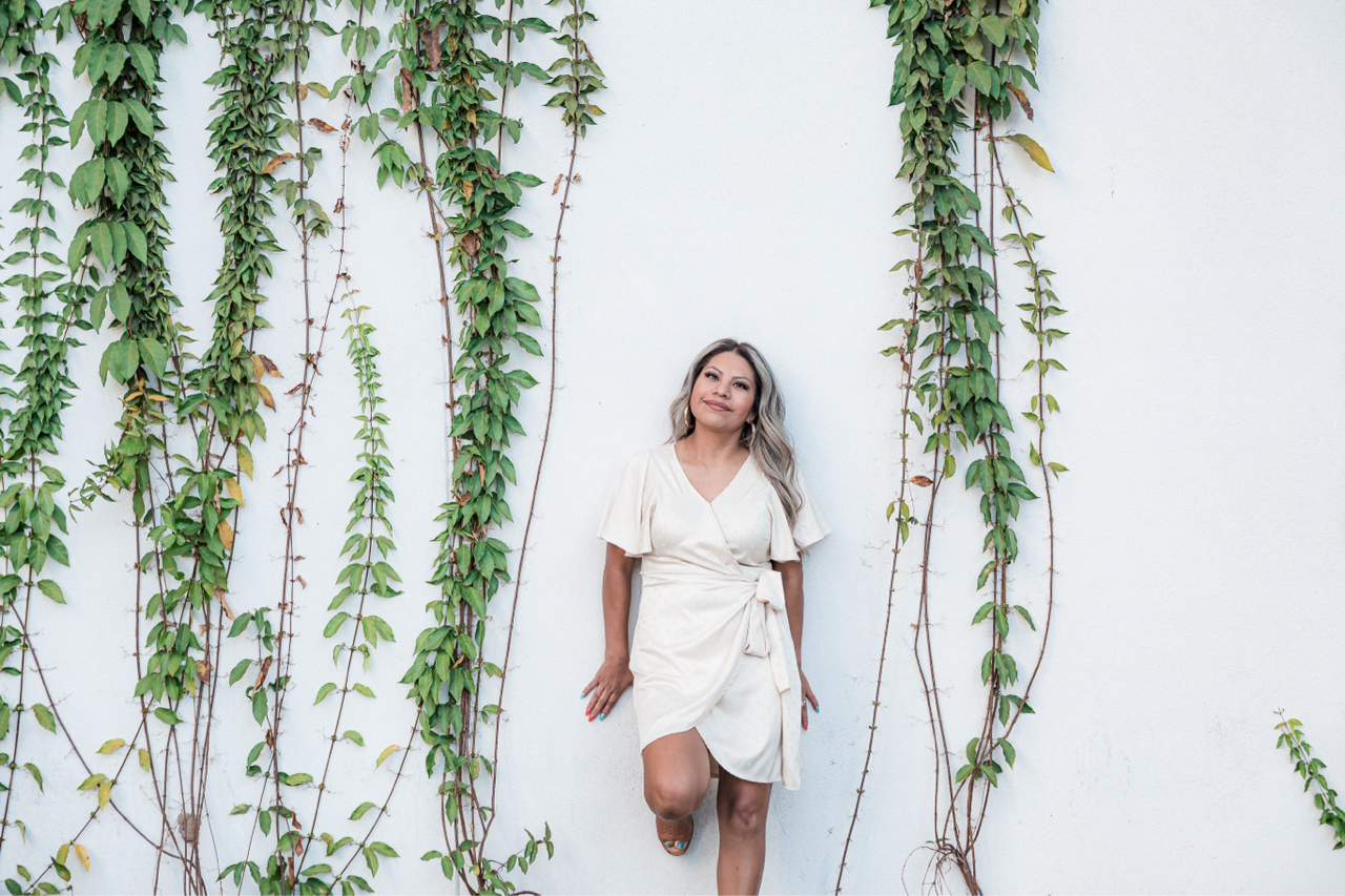 Hair stylist holding a bowl of hair dye, with a client in a salon chair.