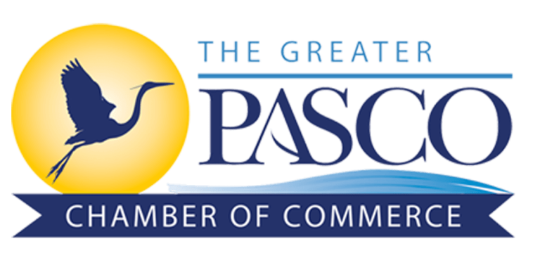 Greater Pasco Chamber of Commerce logo with blue crane and navy text on yellow sun