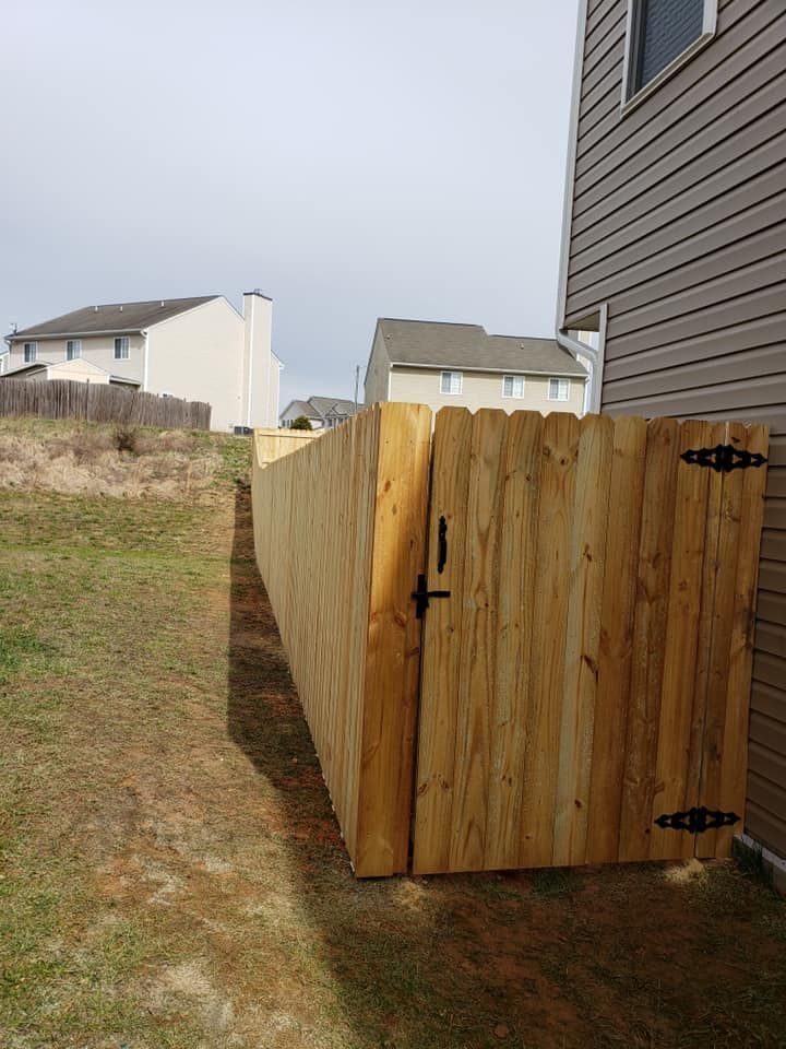 Wooden outdoor storage enclosure beside a house in a grassy yard