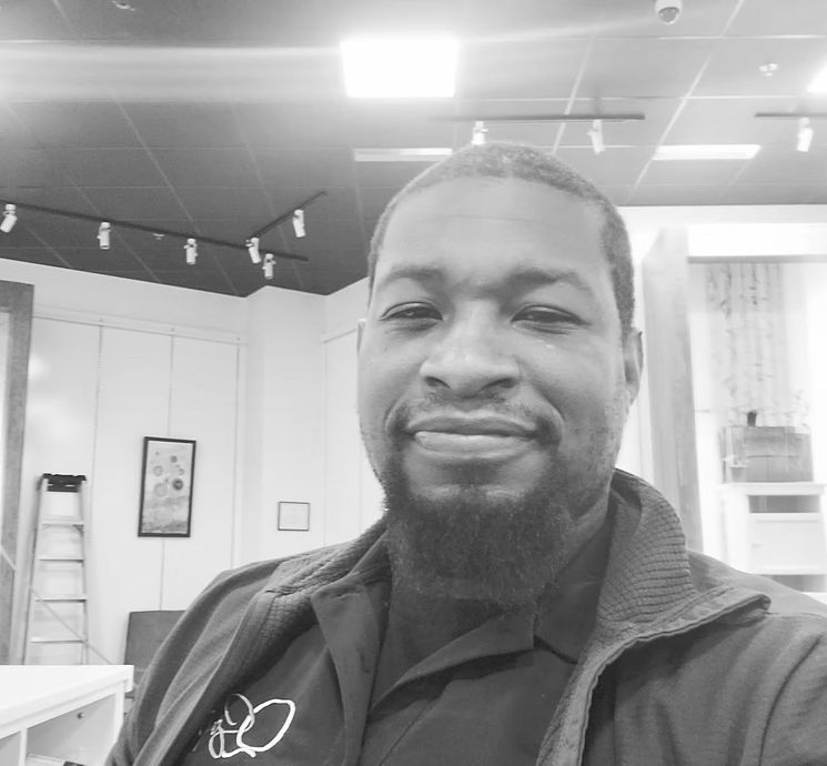 A man with a beard is smiling in a black and white photo