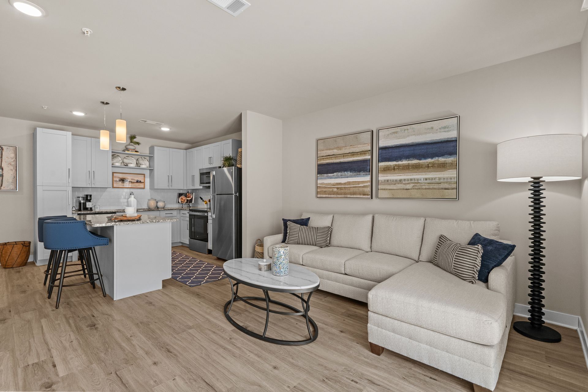 Bedroom with a large bed, nightstands, closet, artwork, and a ceiling fan; light colors.