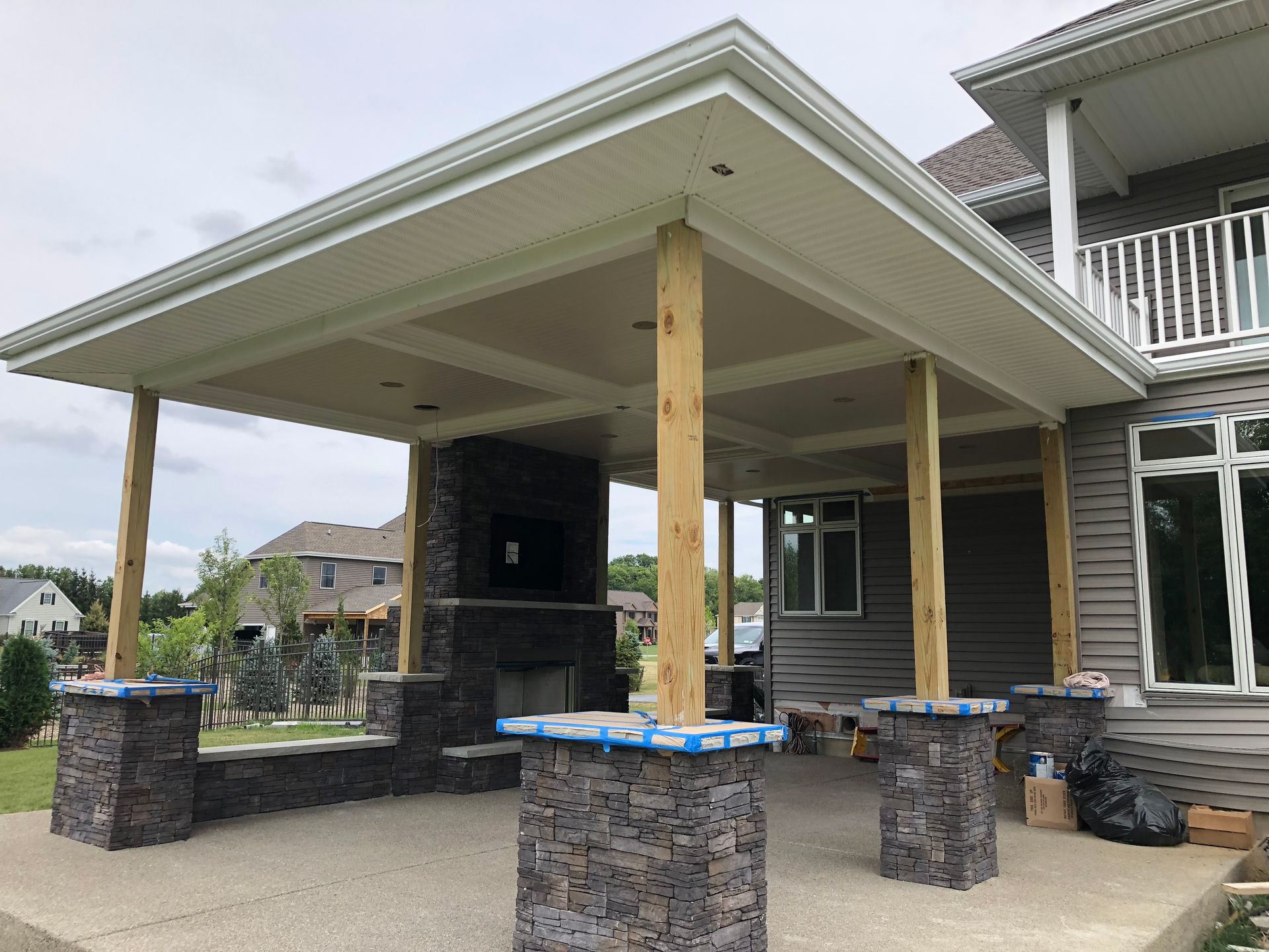 Wood-framed houses under construction against a clear blue sky.
