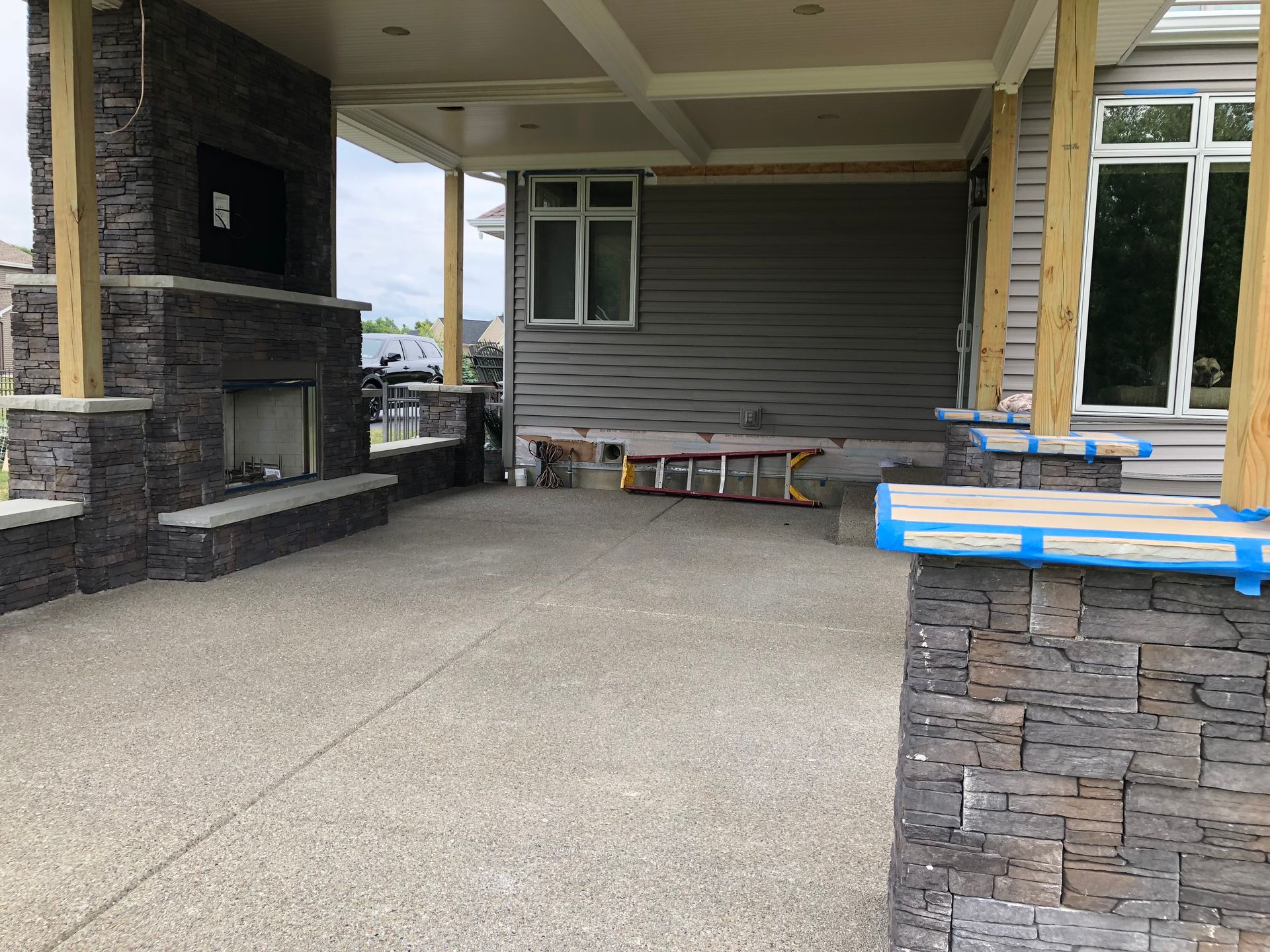 White kitchen with stainless steel appliances and glass-front cabinets against a gray wall.