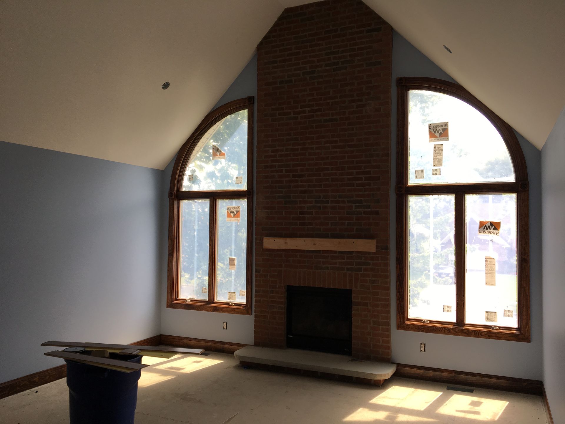 Unfinished basement with concrete floor, exposed beams, water heater, and stairs leading up.