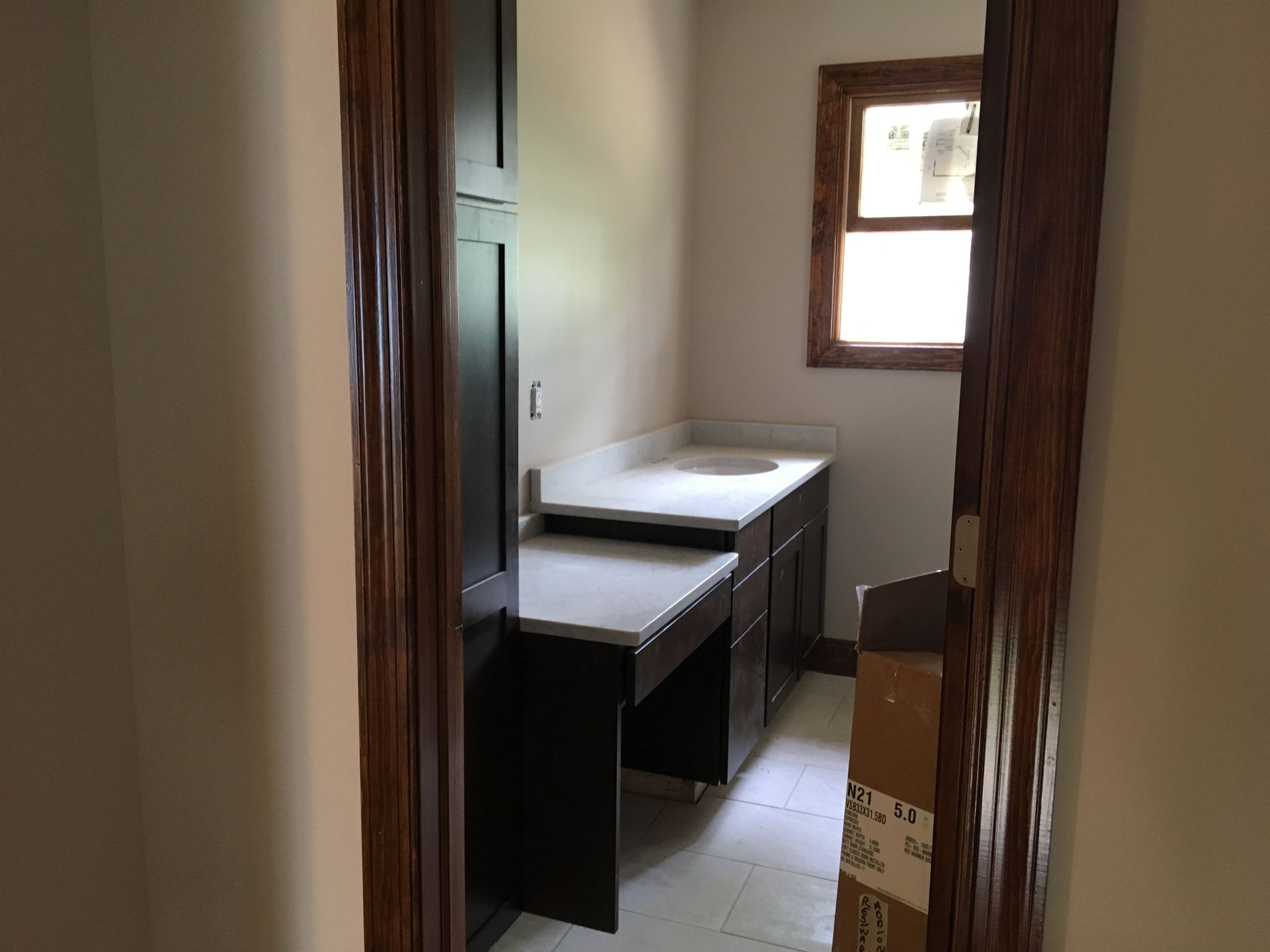 Room under renovation with debris on the floor, construction tools, and open doorway and windows.