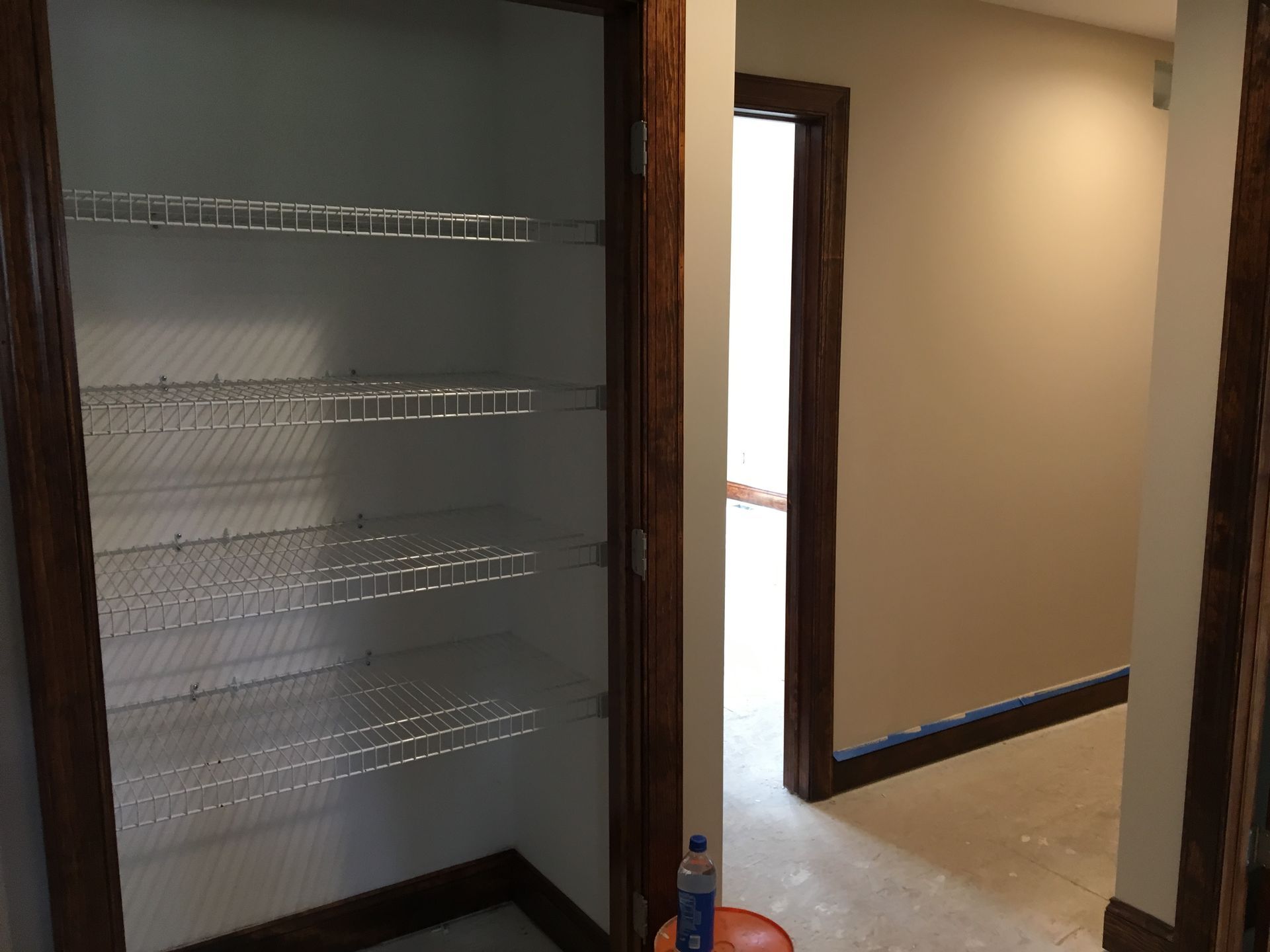 White kitchen with stainless steel appliances, granite countertops, and a window overlooking trees.
