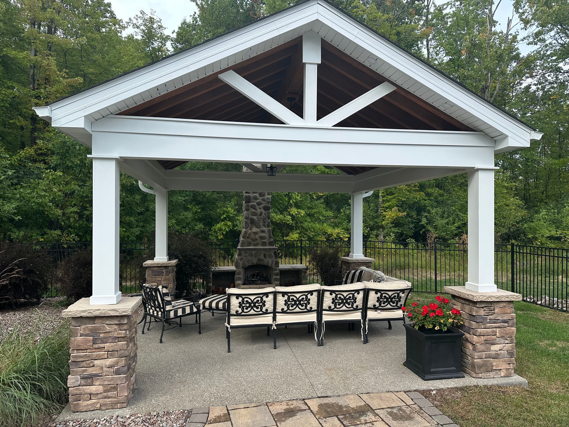 Unfinished basement with concrete floor, exposed beams, water heater, and stairs leading up.