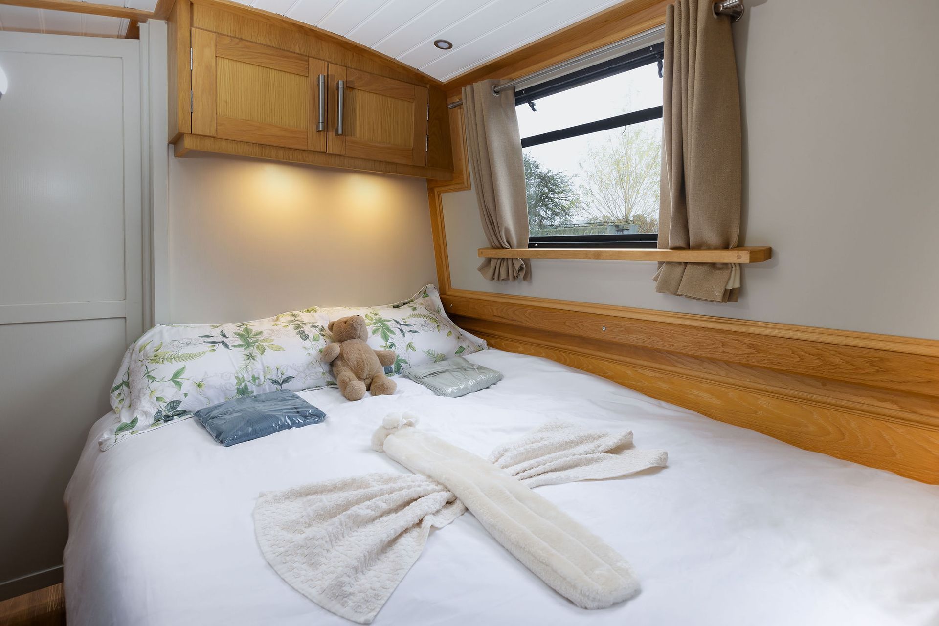 There is a teddy bear on the bed in the room.