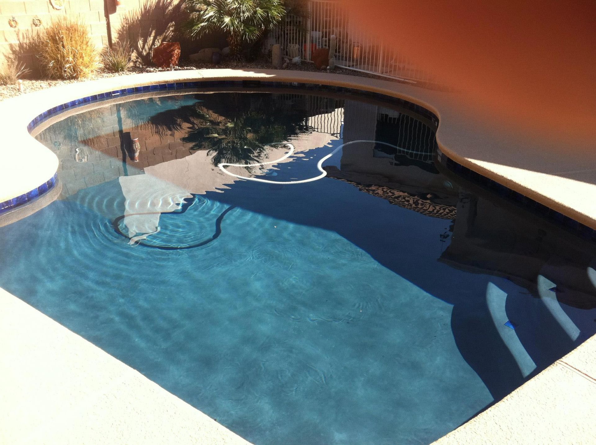 A swimming pool with a reflection of a building in the water