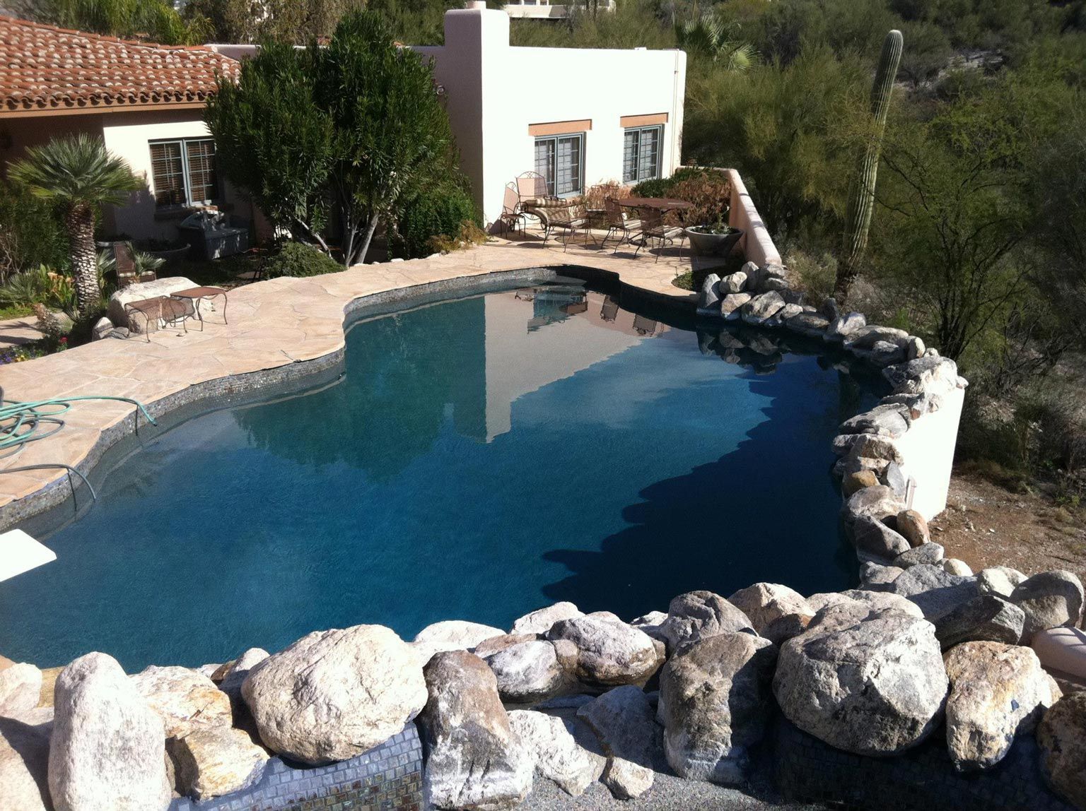 A large swimming pool with a house in the background
