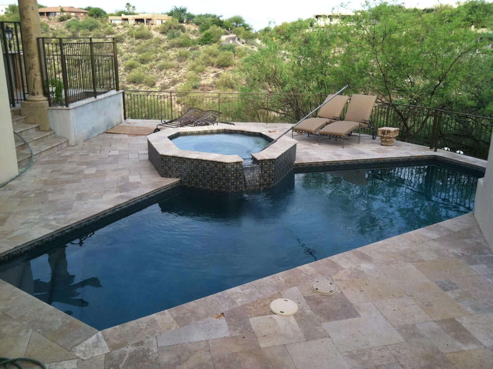 A large swimming pool with a hot tub in the middle