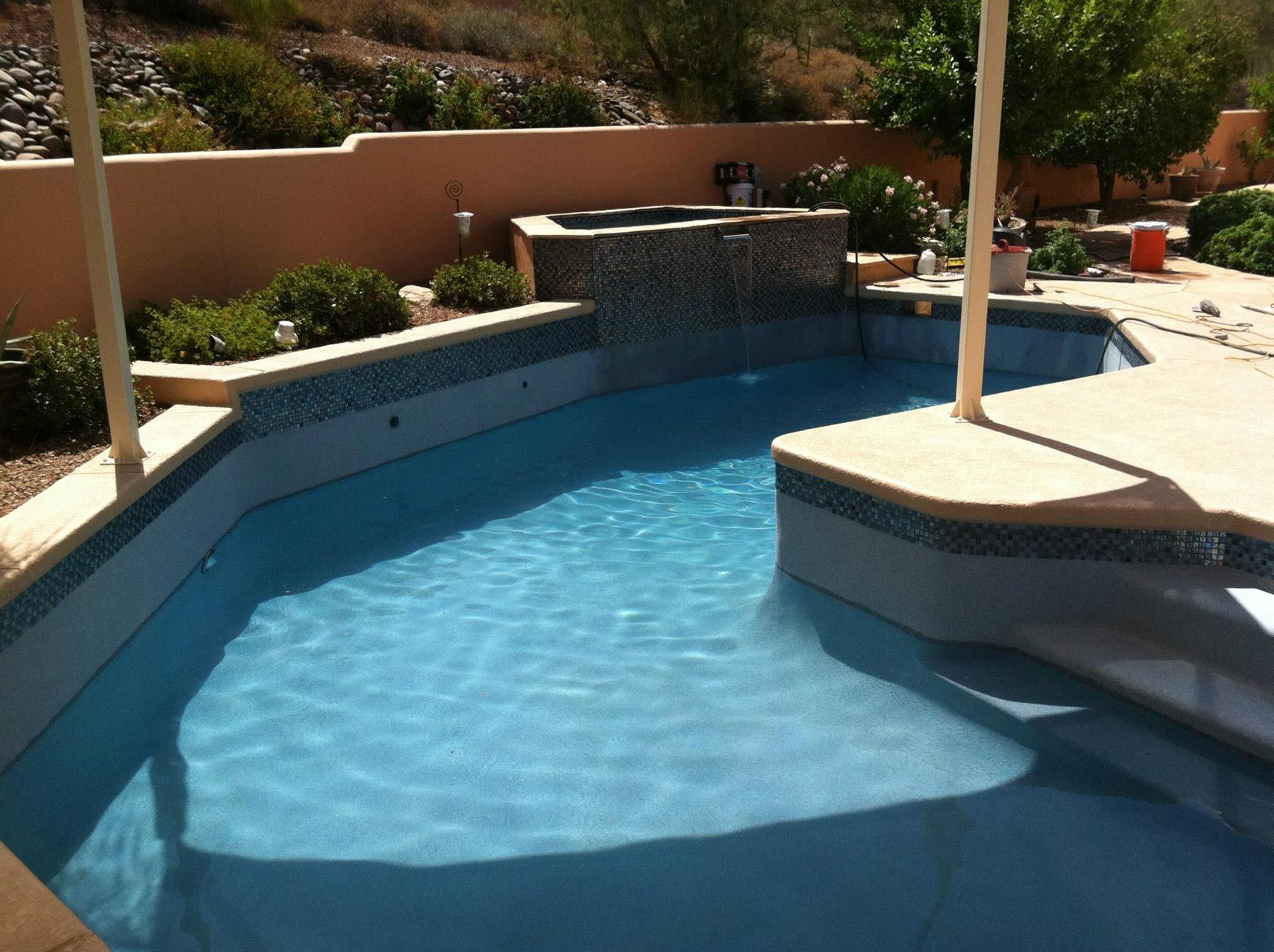 A large swimming pool with a waterfall in the background
