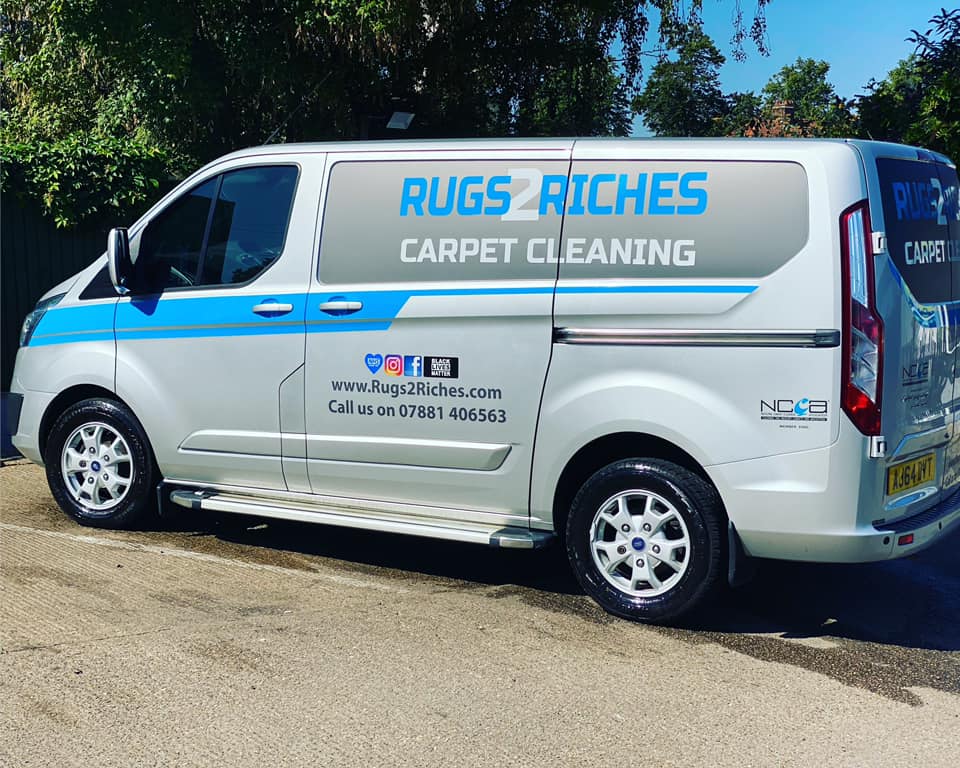 a carpet cleaning van is parked on the side of the road .