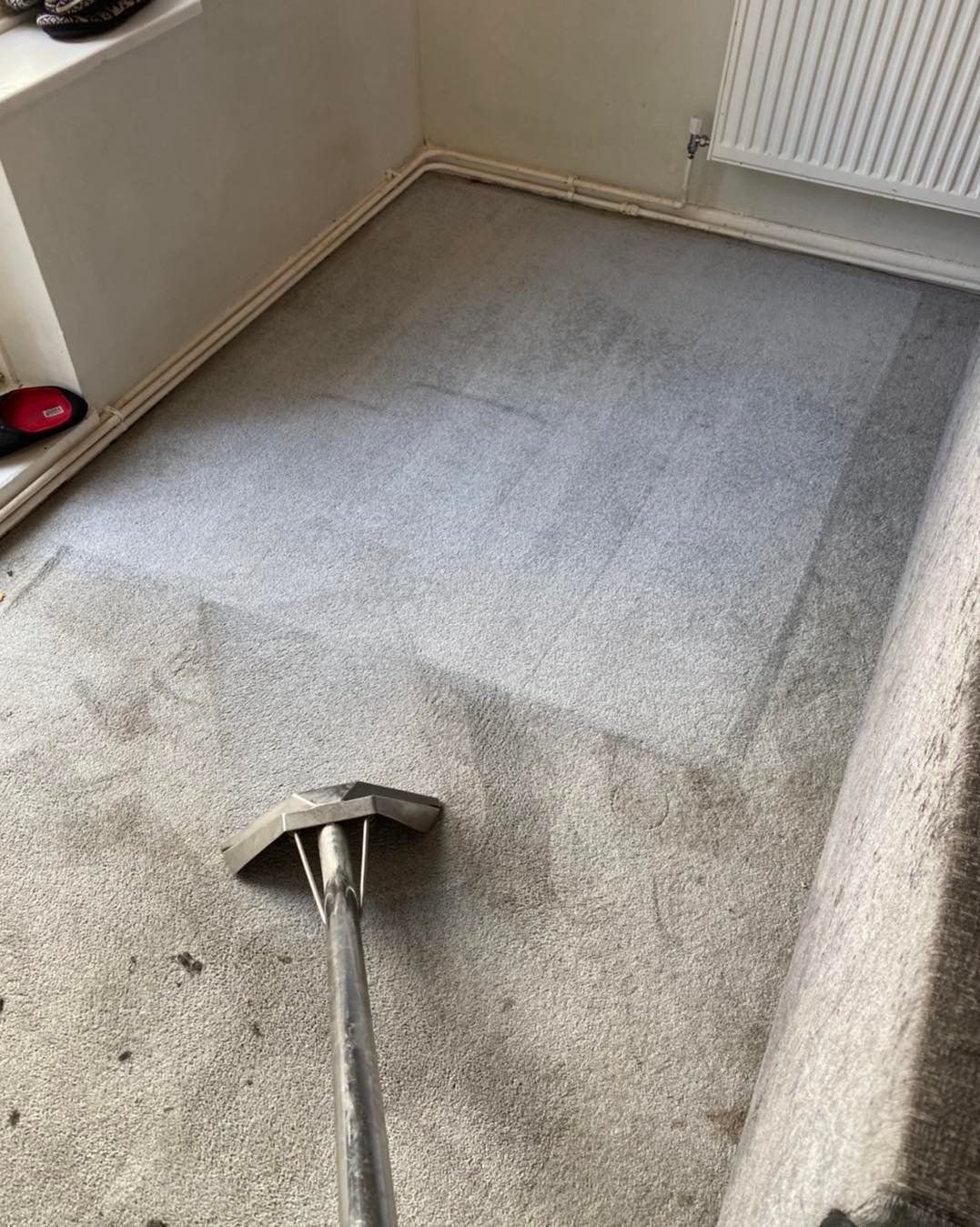 a vacuum cleaner is cleaning a dirty carpet in a room .
