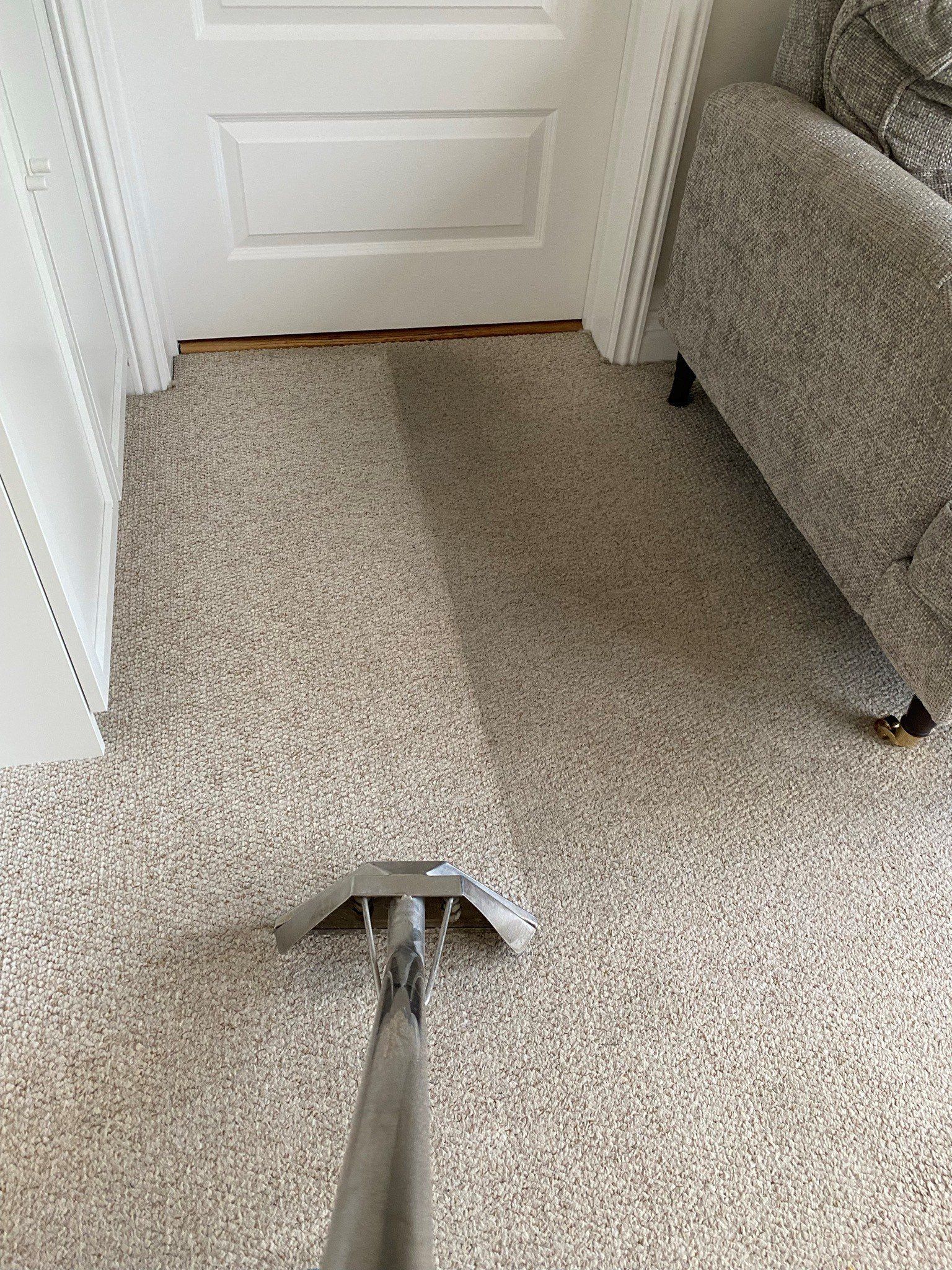 a vacuum cleaner is cleaning a carpet in a living room .