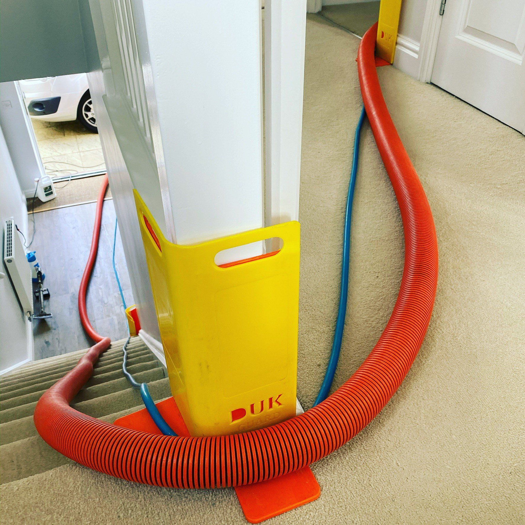 a red vacuum hose is attached to a yellow pole