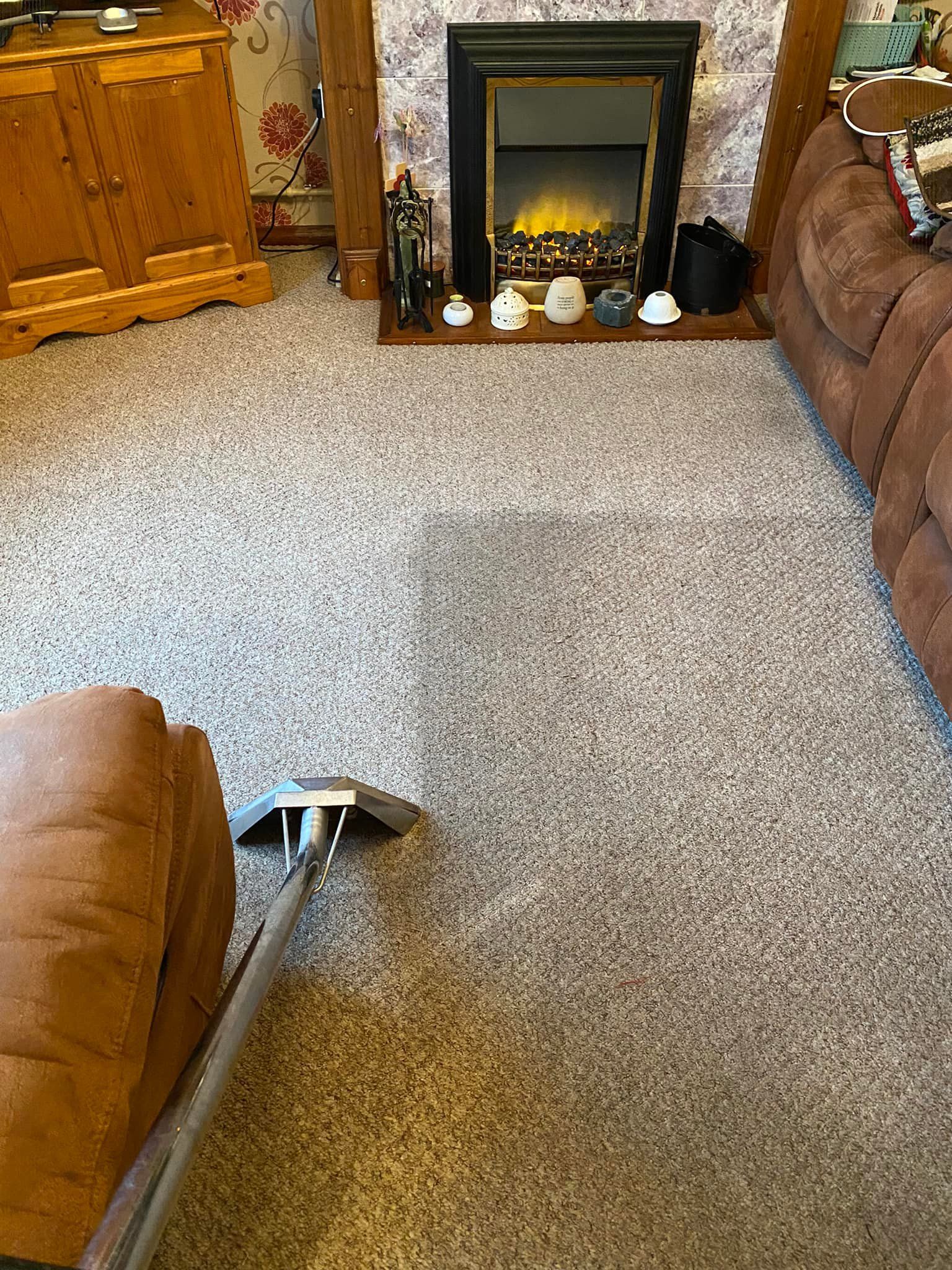 a living room with a fireplace and a vacuum cleaner on the floor .