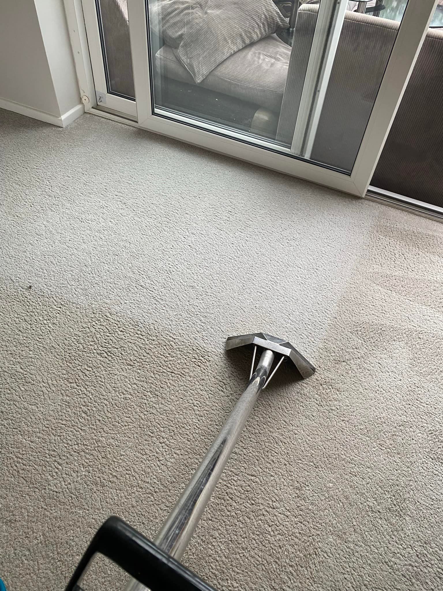 a vacuum cleaner is cleaning a carpet in a living room .