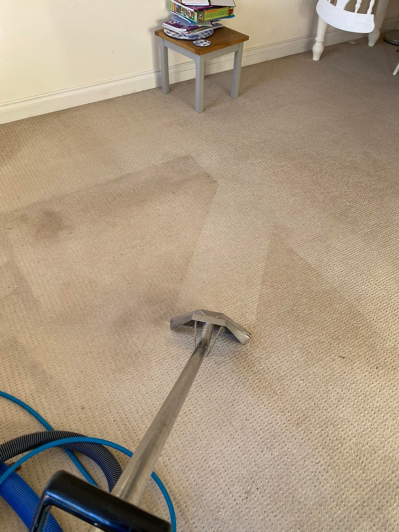 a vacuum cleaner is cleaning a carpet in a living room .