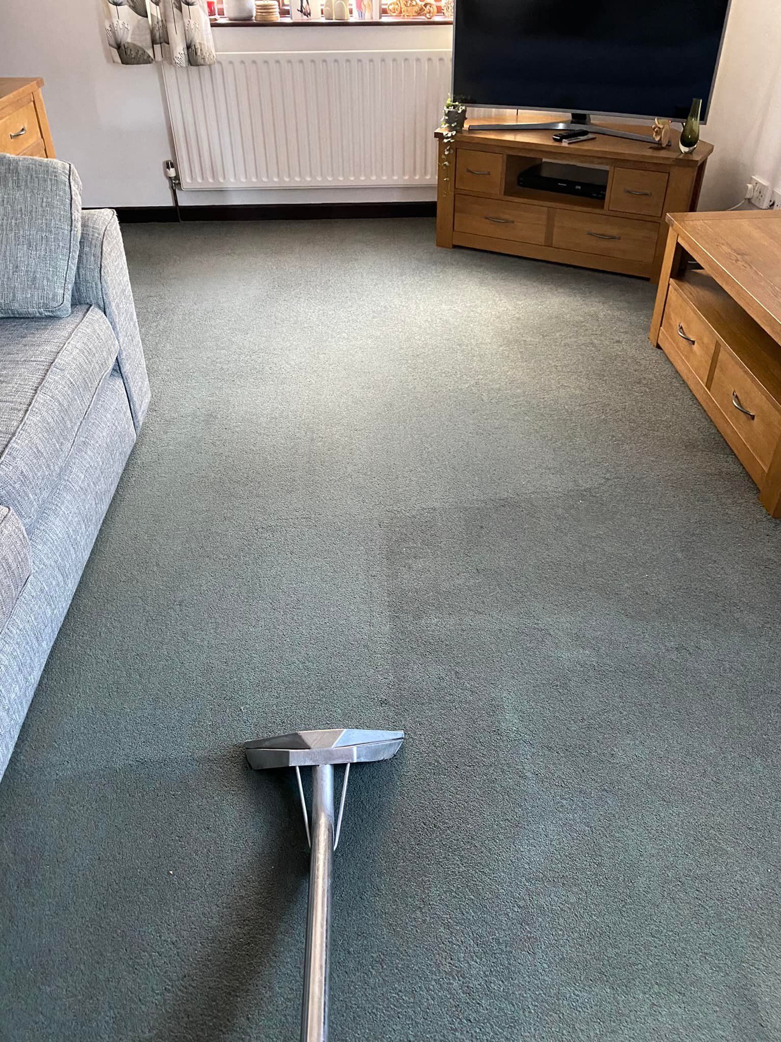 a vacuum cleaner is sitting on a carpet in a living room .