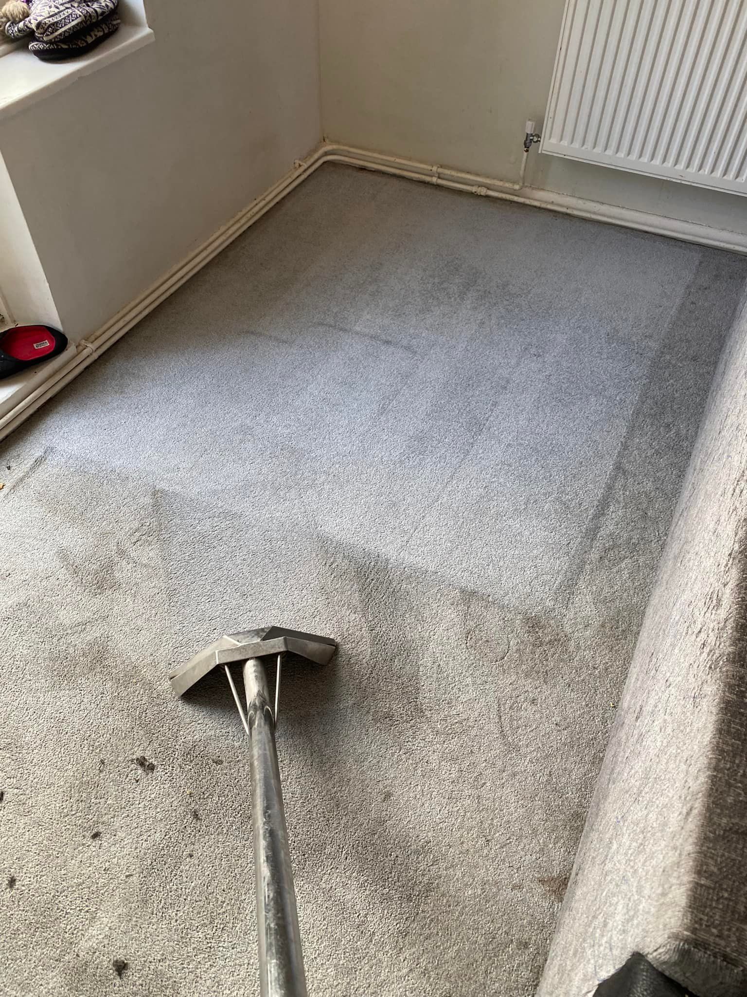a vacuum cleaner is cleaning a carpet in a room .