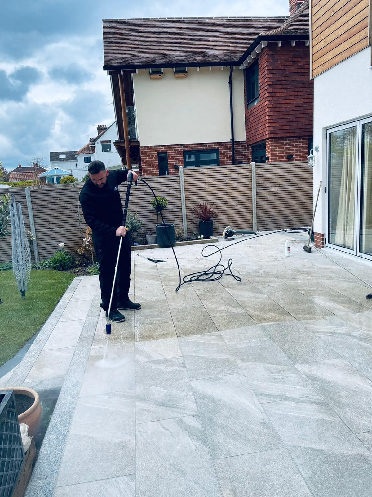 a man is cleaning a patio with a broom in front of a house .