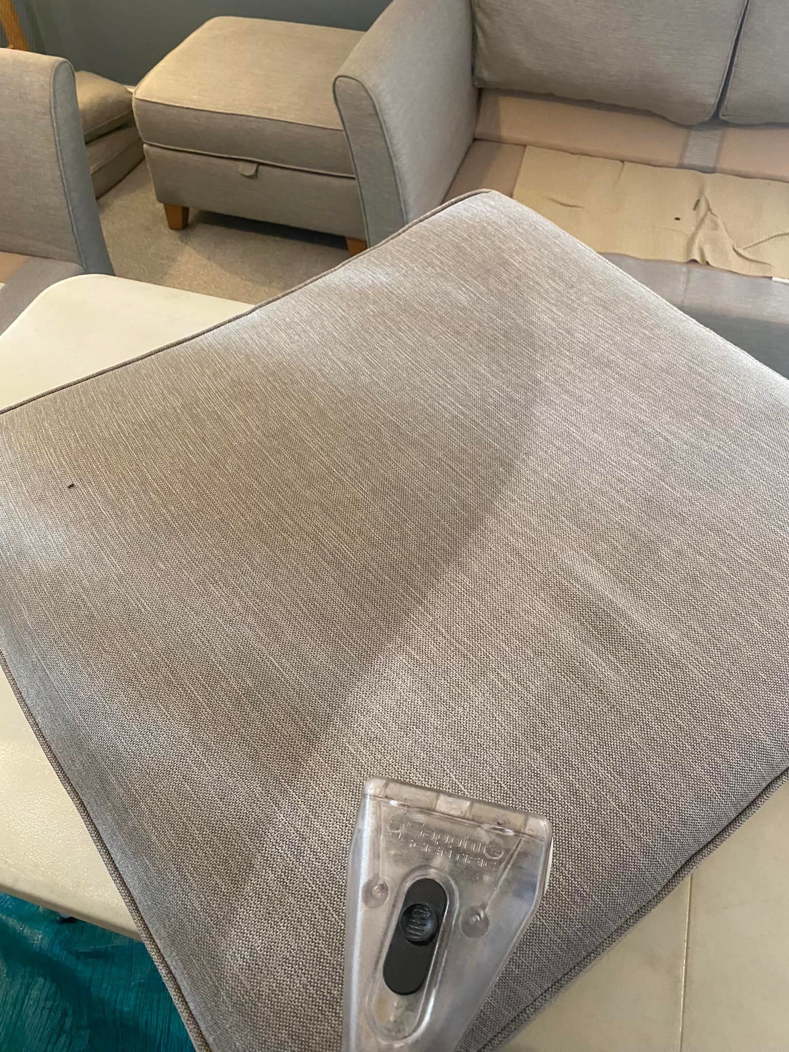 a couch is being cleaned with a vacuum cleaner in a living room .