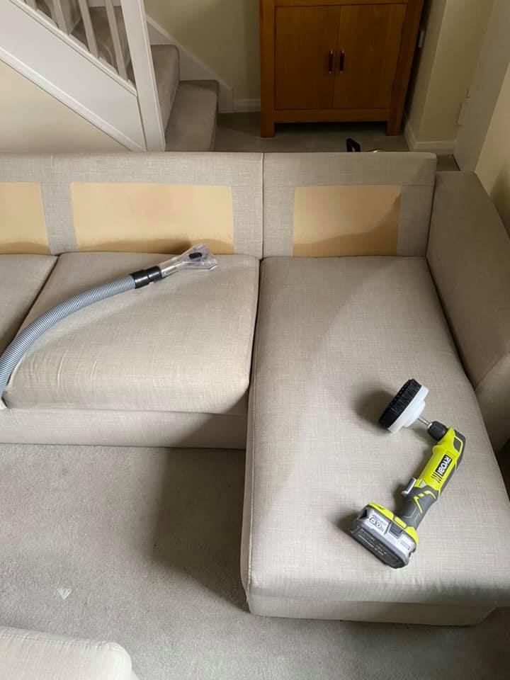 a vacuum cleaner is sitting on top of a couch in a living room .