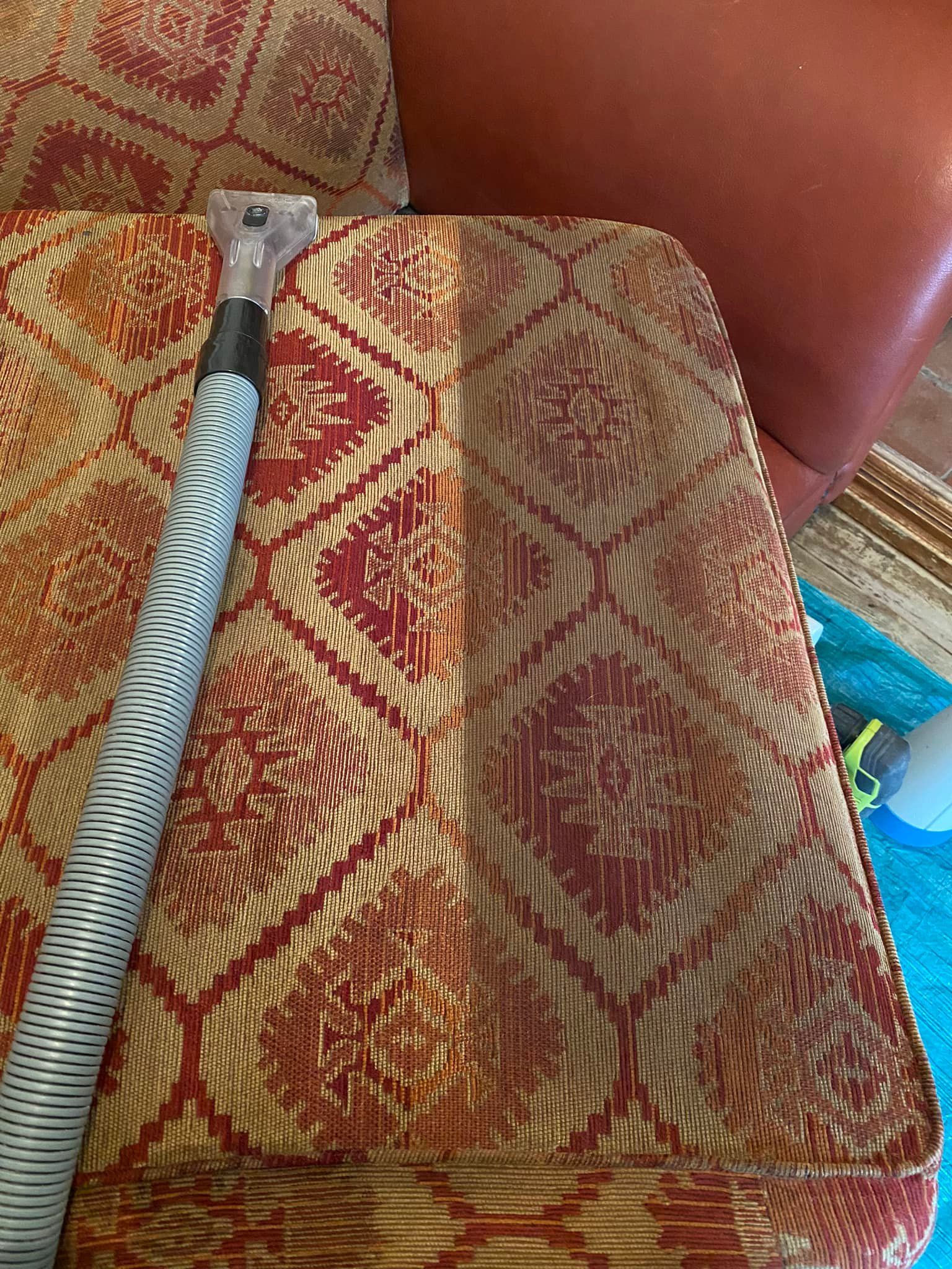 a vacuum cleaner is sitting on top of a couch .