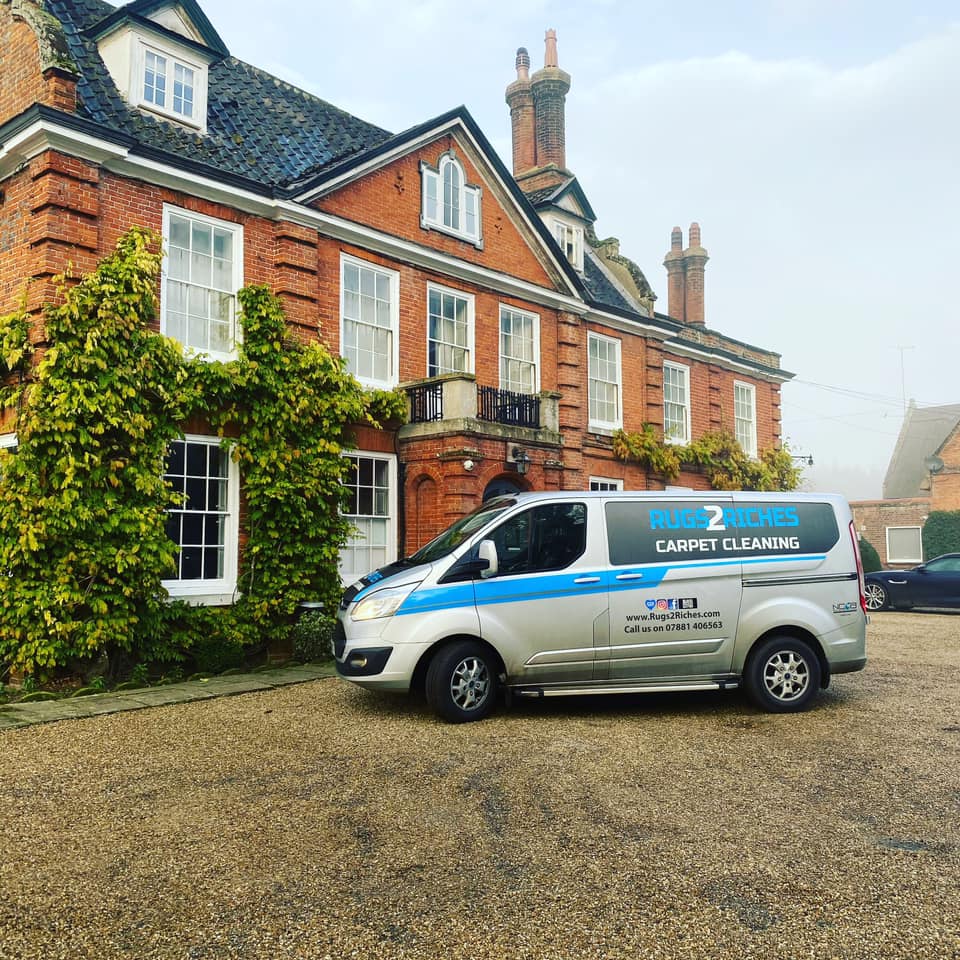 a van is parked in front of a large brick building .