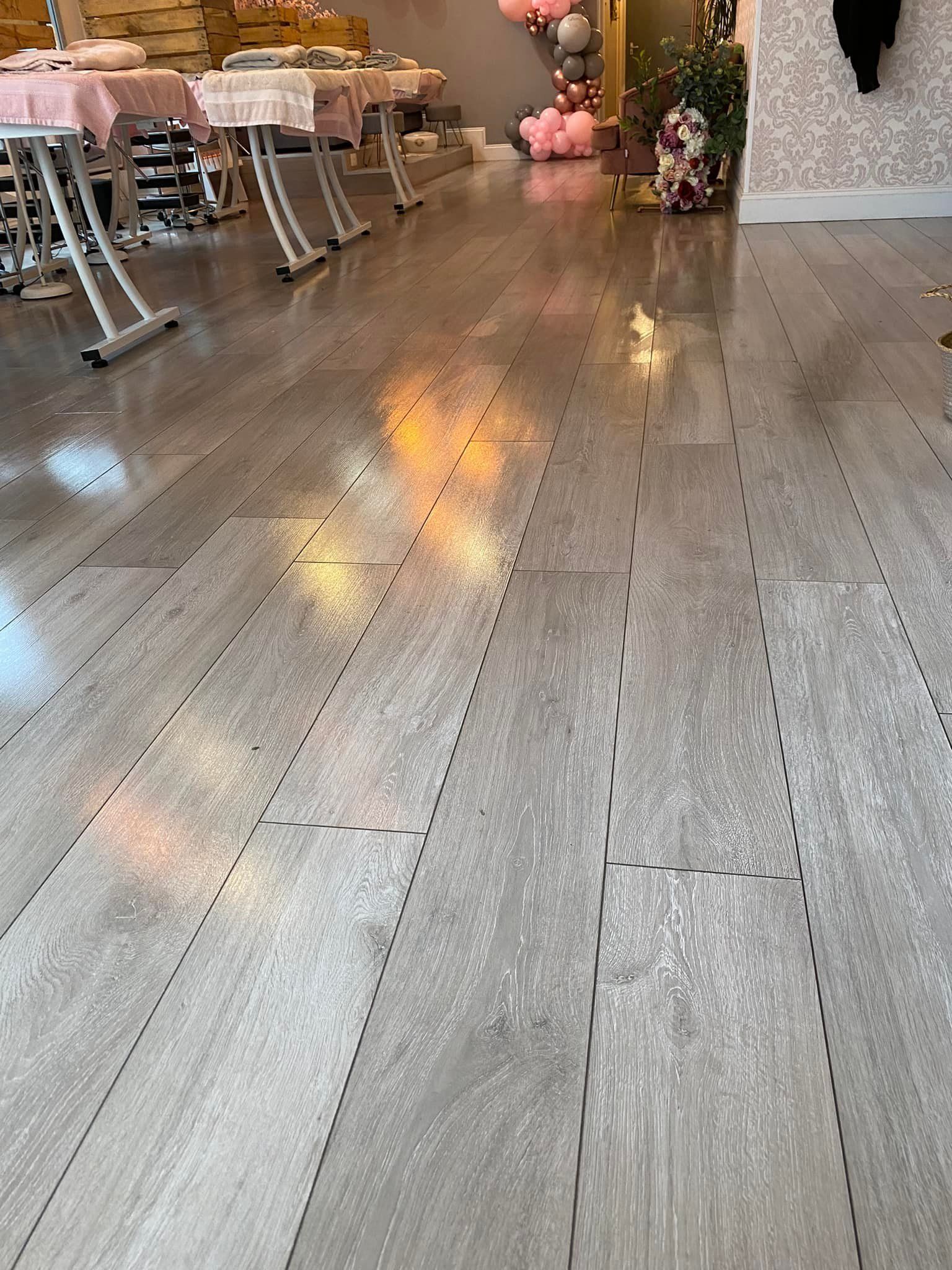 a wooden floor in a room with tables and chairs .