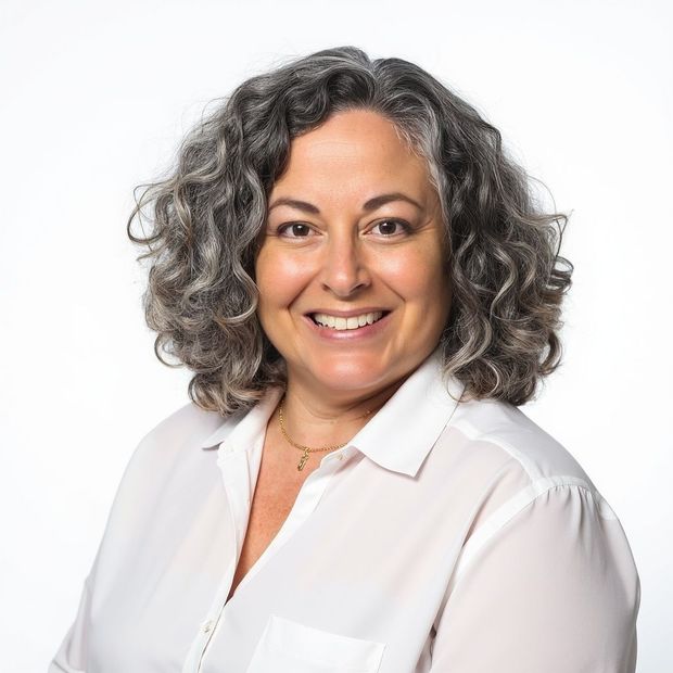 A woman with curly hair wearing a black shirt smiles for the camera