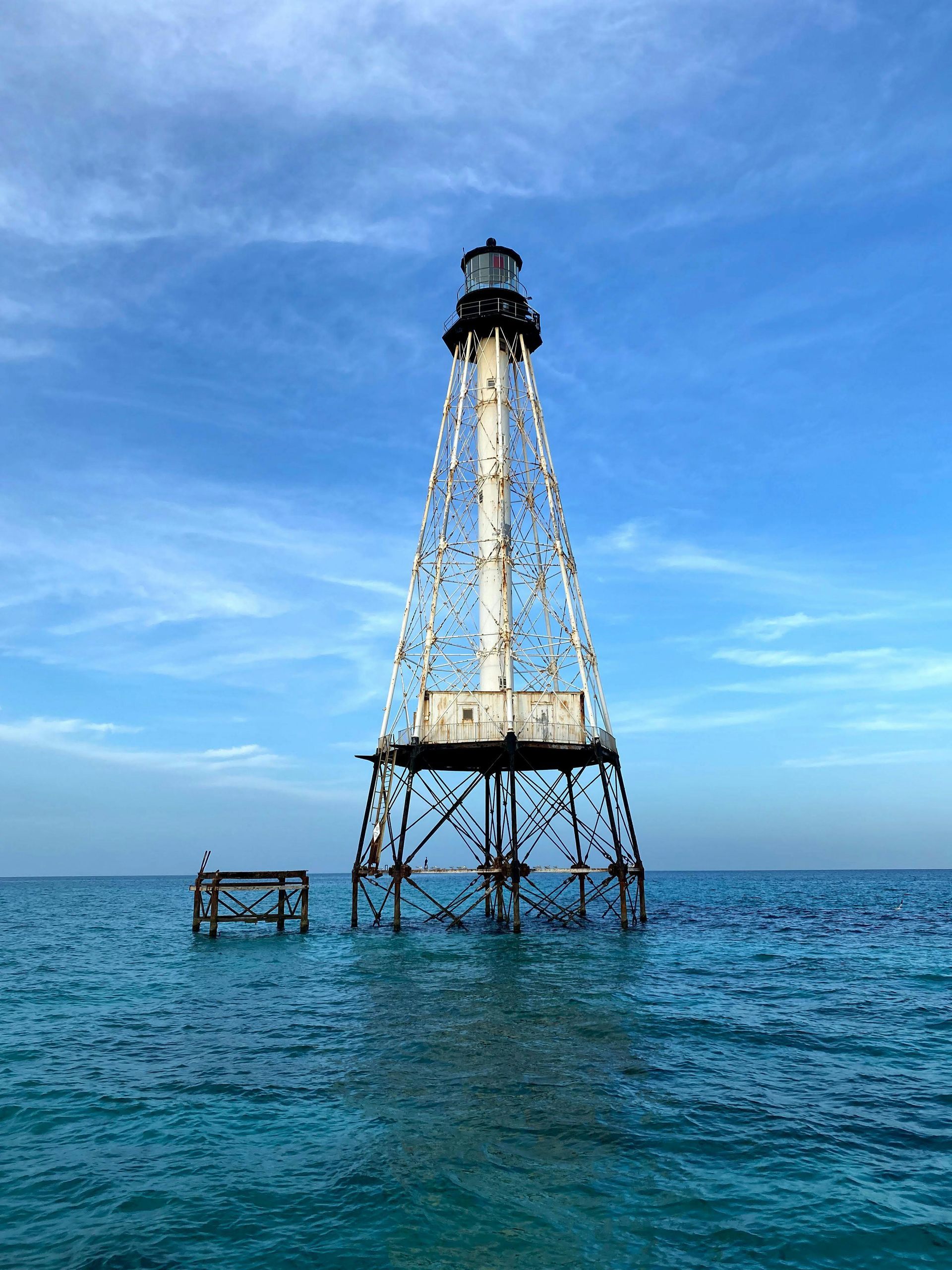 A lighthouse is in the middle of the ocean