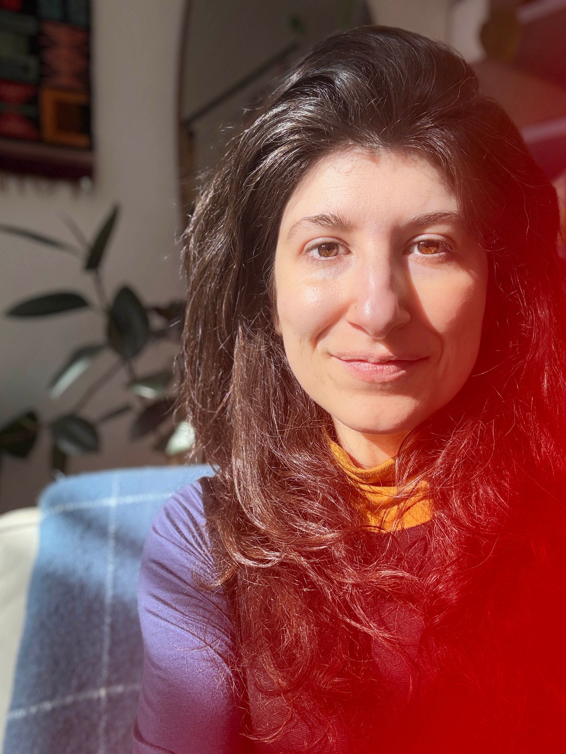 Headshot of Cristina Maria Fort Garces on a purple background.