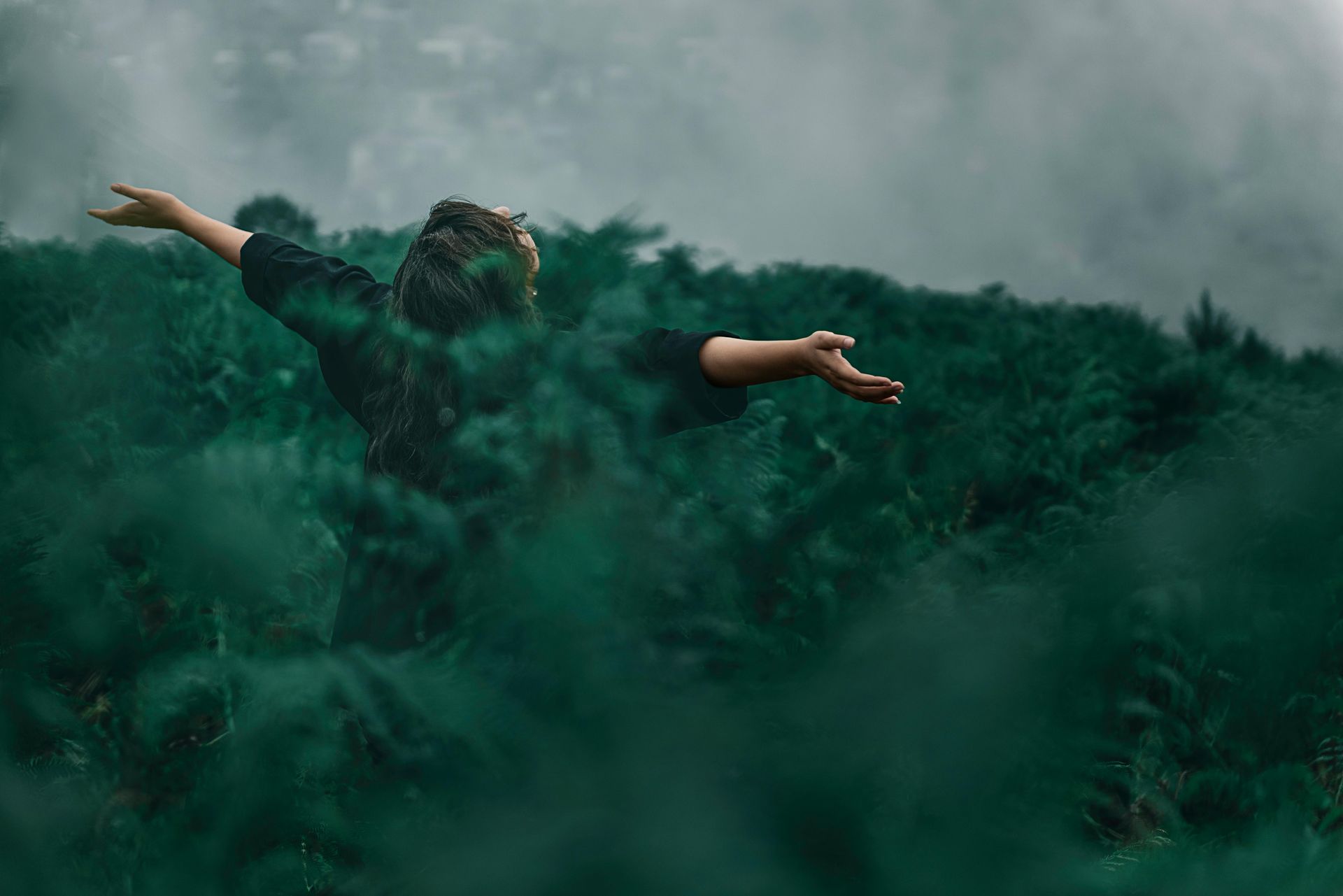 Woman in a field with arms open.