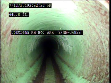 View inside a tunnel with green and brown walls. Text: 440.8 ft., Upstream MH No: ANH SNKH-04855.