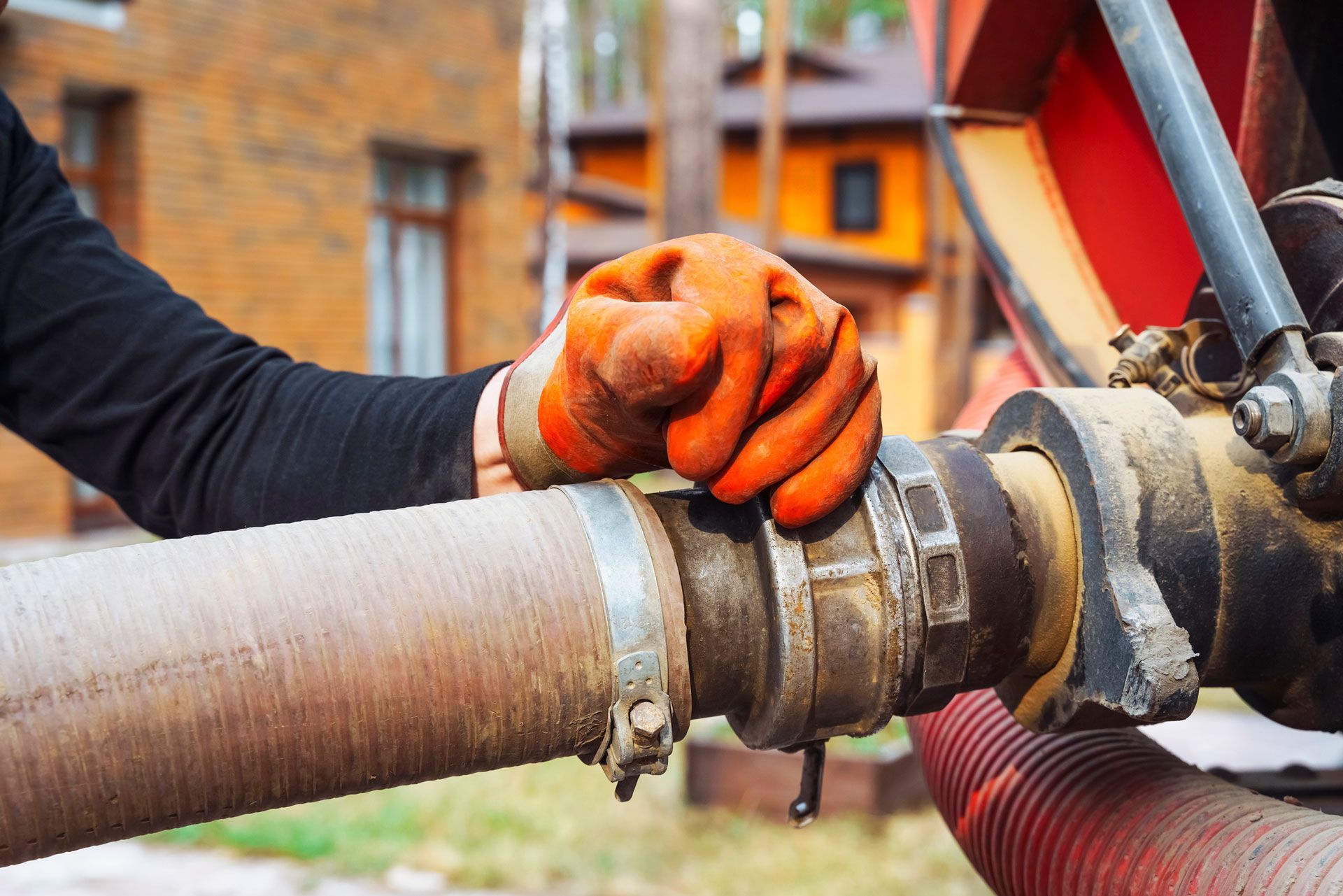 a hand connects a suction hose to a sewage tanker truck. Sewer pumping machine. Septic truck.