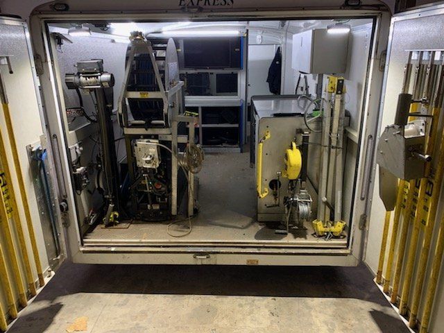 Interior view of a trailer filled with industrial equipment, possibly for specialized testing or repair.