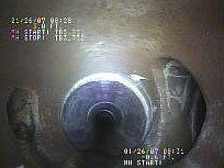 Inside a pipe: cylindrical object lit up, with a hole to the right. Date and time stamps are visible.