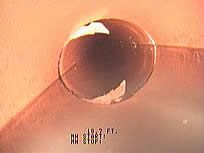 Close-up of a large, dark bubble resting on a corner, reflecting the surrounding environment.