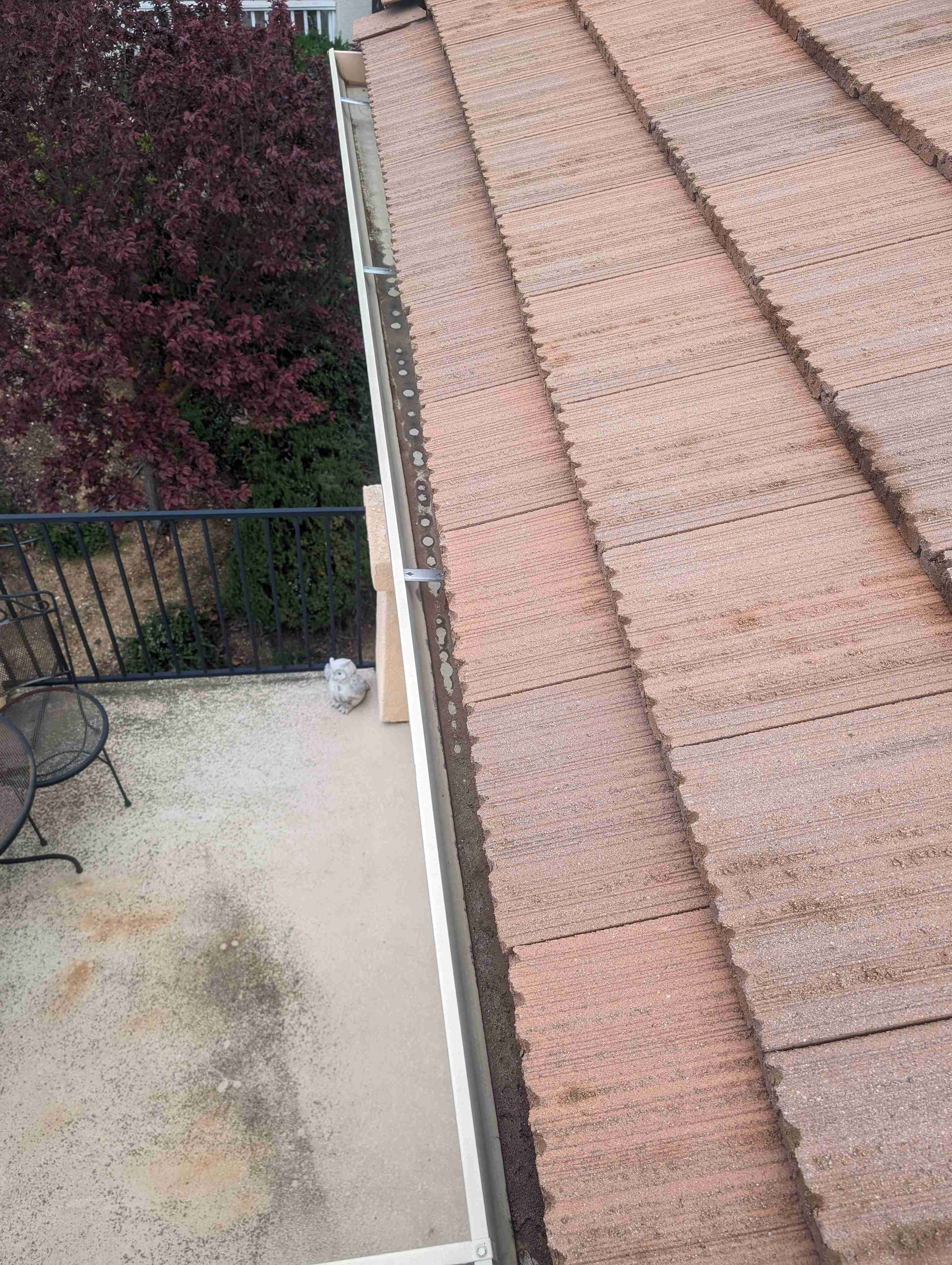 There is a gutter on the roof of a house.