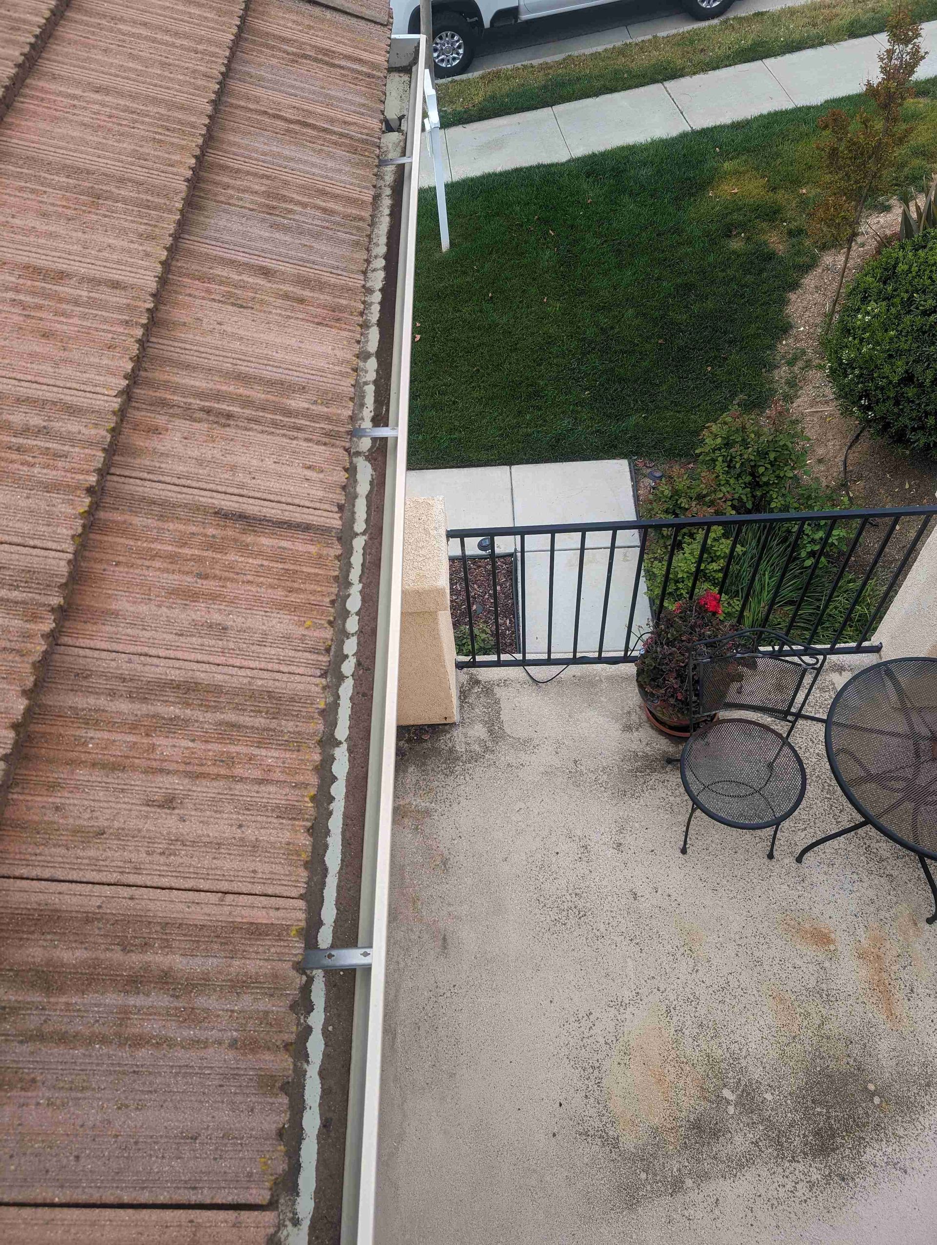 Aerial view of a balcony with a table and chairs.