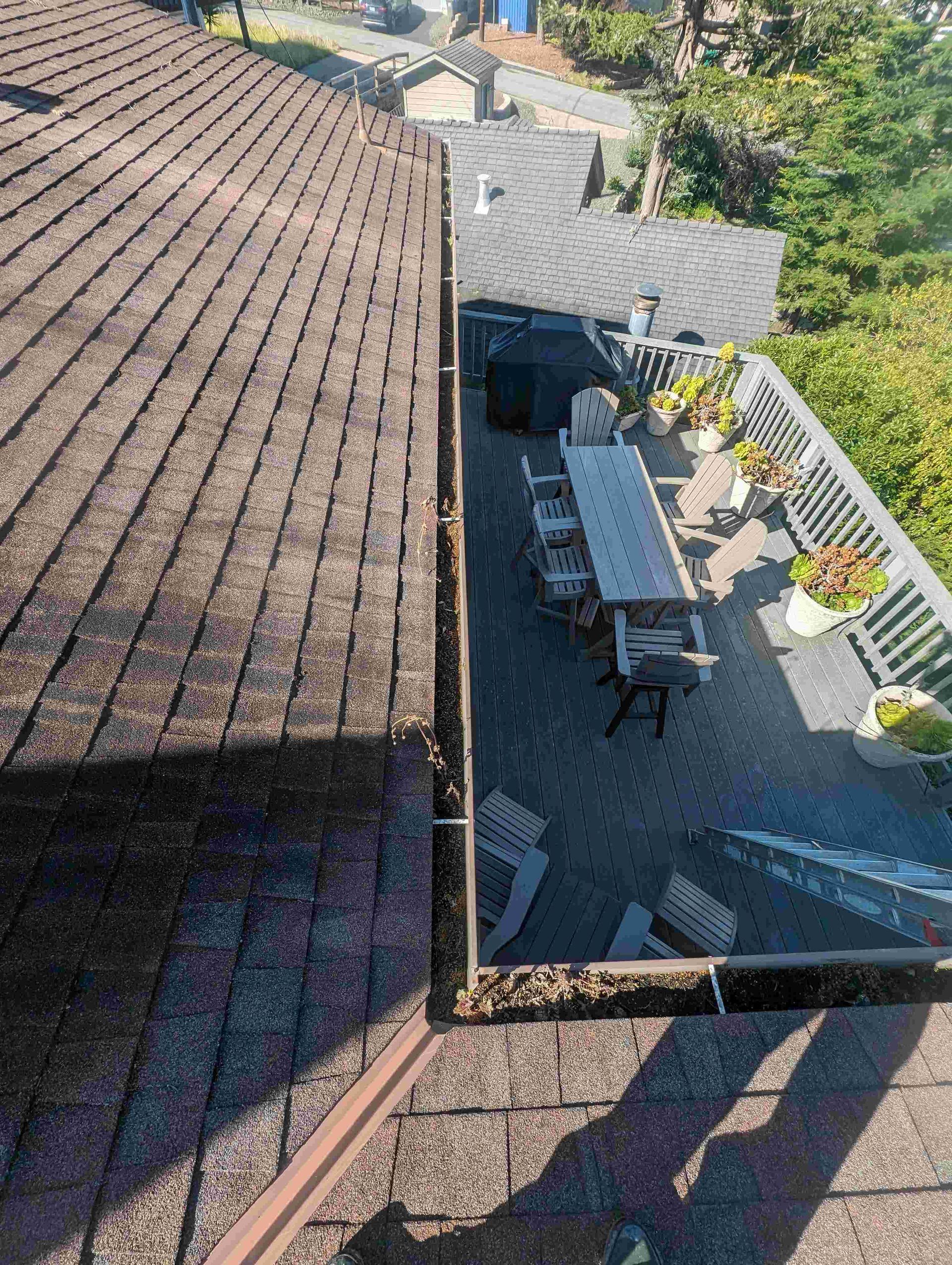Aerial view of a roof with a table and chairs on it.