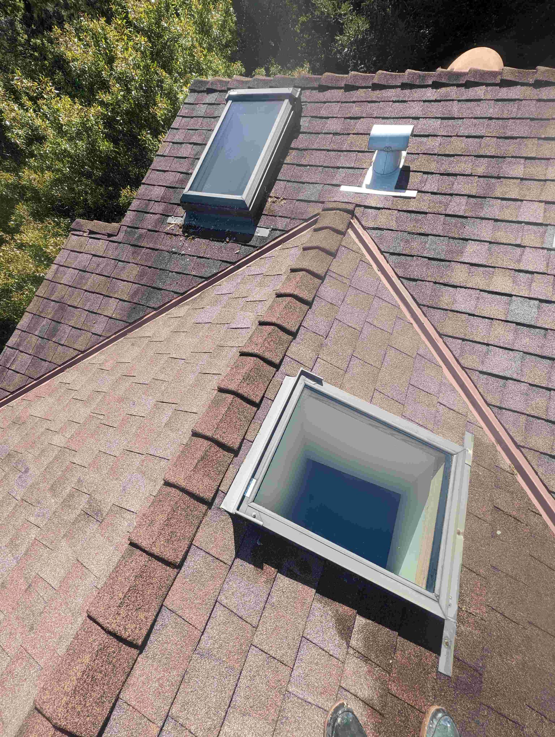 There are two skylights on the roof of a house.