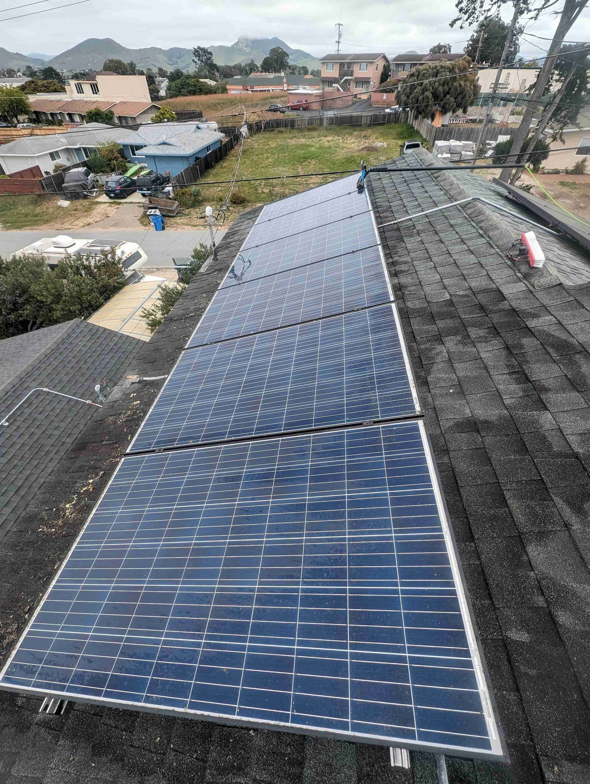Row of solar panels sitting on top of a roof.