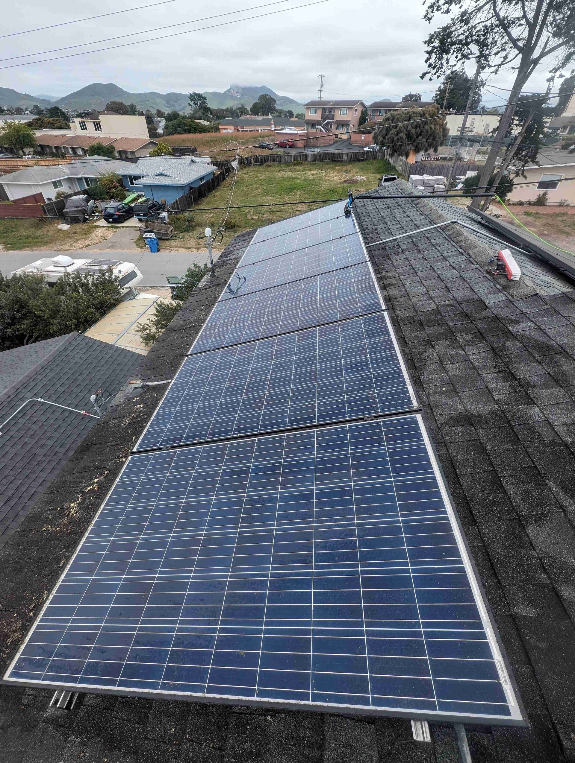 Row of solar panels are sitting on top of a roof.