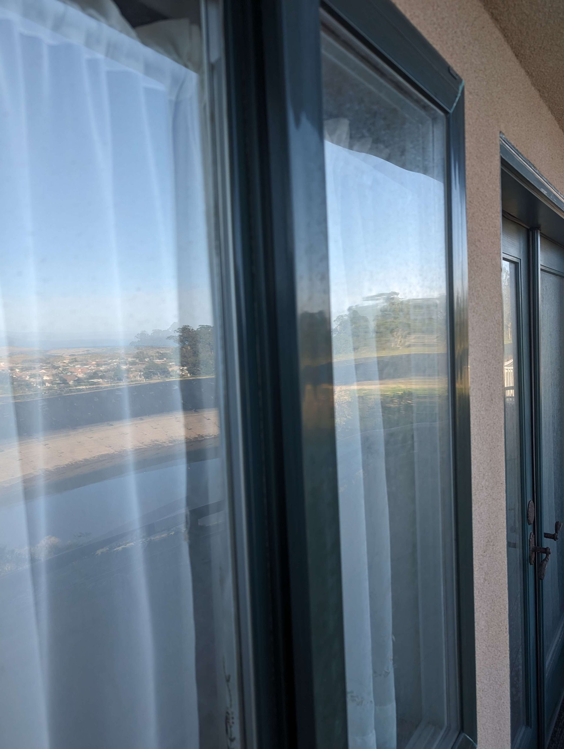 A close up of a window with curtains on it.